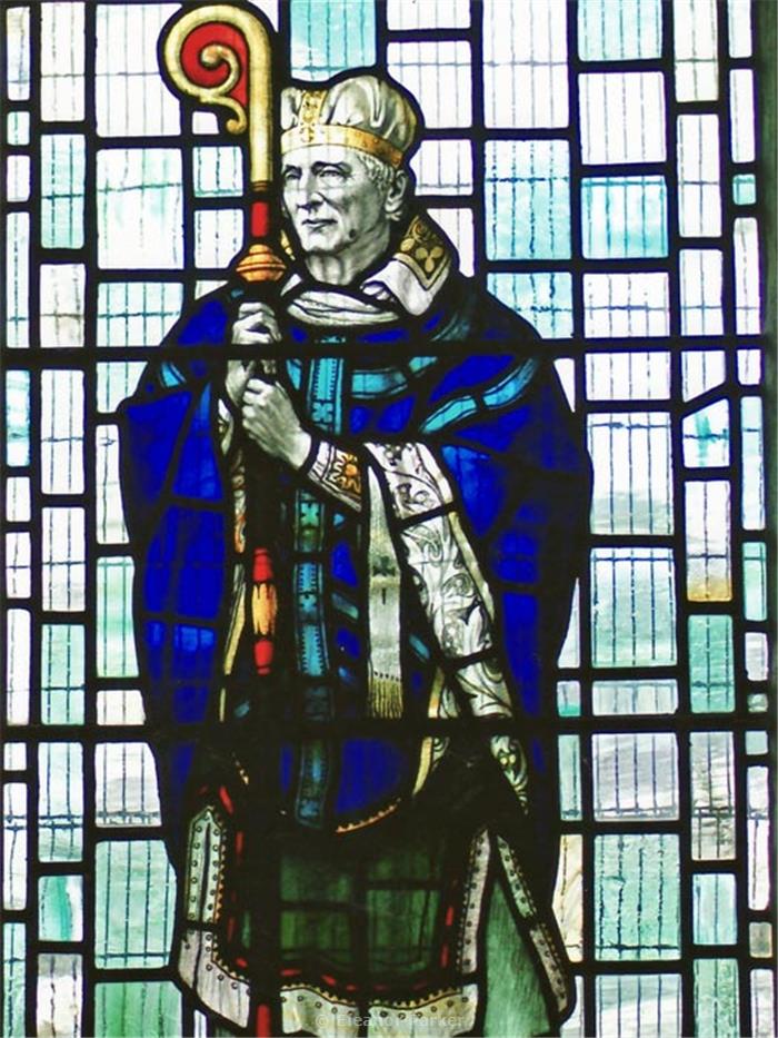 This stained glass panel shows a man dressed in blue, holding a hooked crozier. This is Ælfric, dressed in his role as Abbot of Eynsham. 